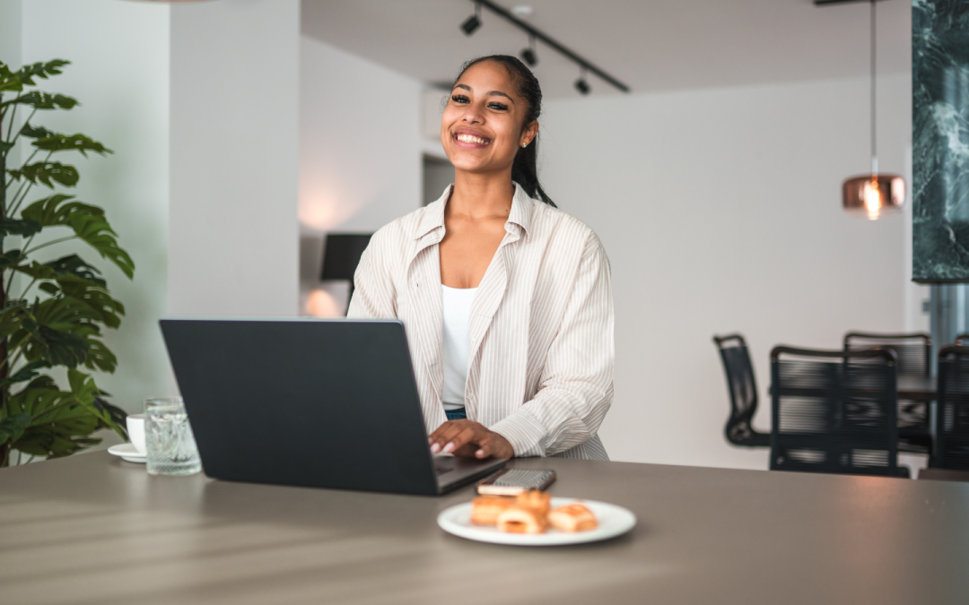 Smiling virtual assistant working on her laptop at home.